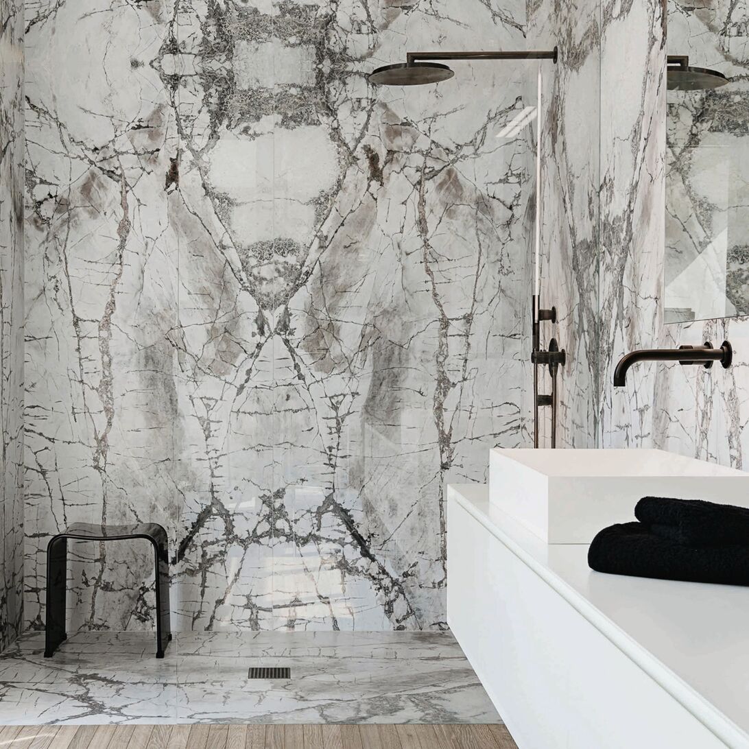 Elegante Marmormuster an Wänden und Böden schaffen eine edle Atmosphäre. Schwarze Armaturen und Akzente setzen moderne Kontraste in diesem stilvollen Raum. Elegante Marmormuster an Wänden und Böden schaffen eine edle Atmosphäre. Schwarze Armaturen und Akzente setzen moderne Kontraste in diesem stilvollen Raum.