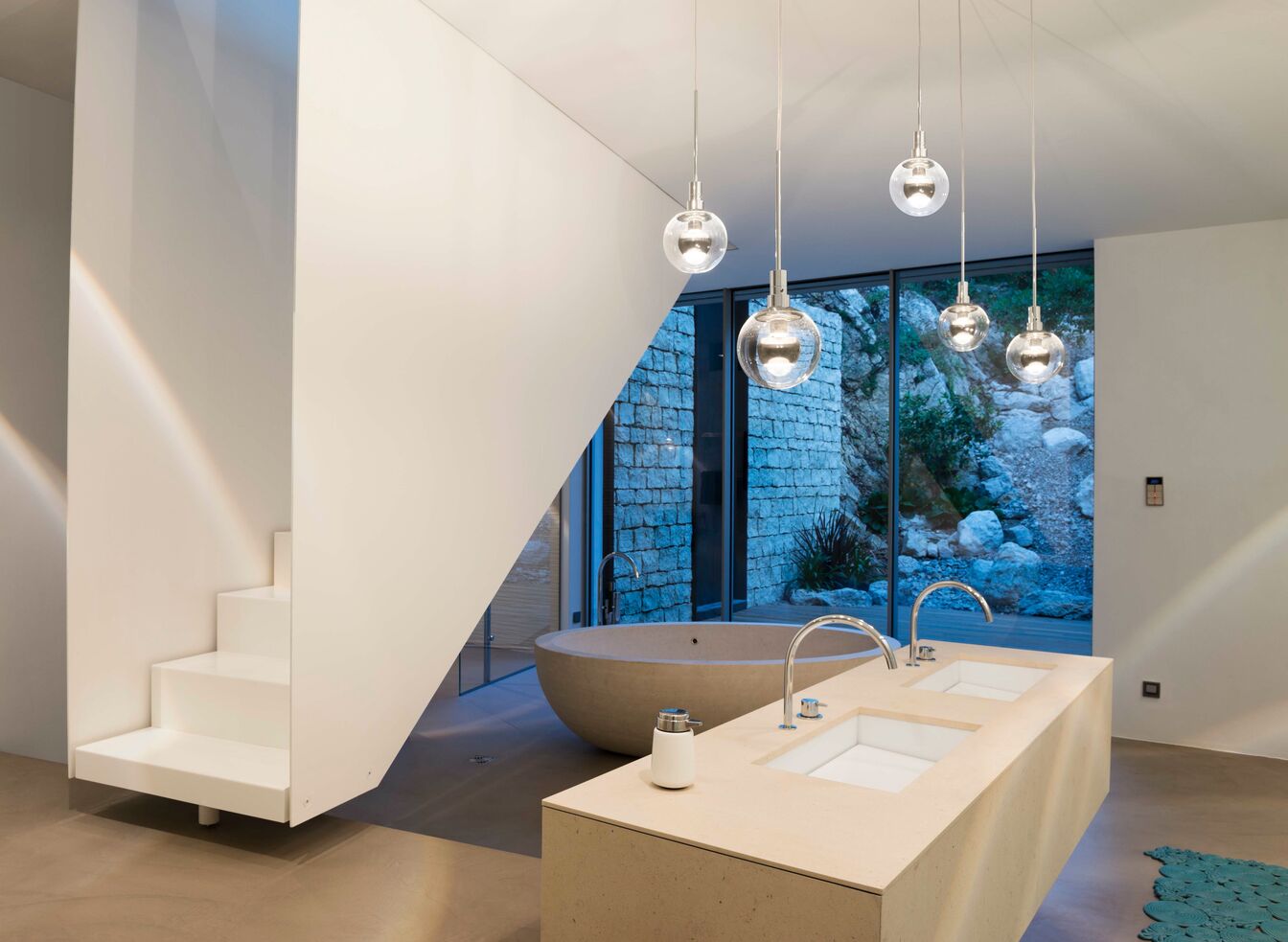 Modernes Badezimmer mit einer eleganten freistehenden Badewanne vor einem großen Fenster. Doppelwaschbecken und stilvolle Hängelampen sorgen für ein minimalistisches Design. Modernes Badezimmer mit einer eleganten freistehenden Badewanne vor einem großen Fenster. Doppelwaschbecken und stilvolle Hängelampen sorgen für ein minimalistisches Design.